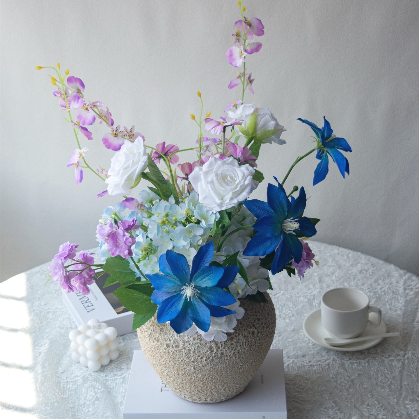 Blue Purple Artificial Bouquet,in a decorative pot on a table with a teacup.