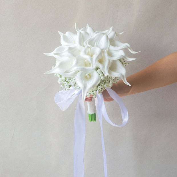 Handmade lifelike artificial white calla lily bouquet held with ribbons for wedding decoration.