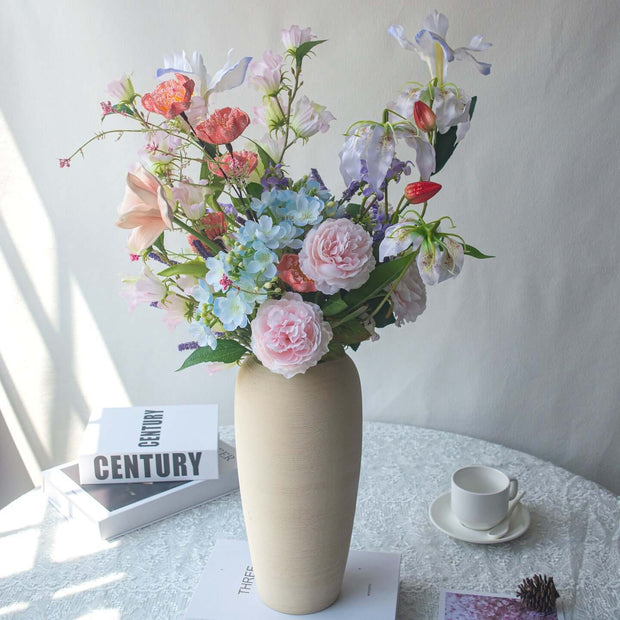 Realistic artificial Peony flower arrangement in vase, handmade table decor with various colorful flowers.