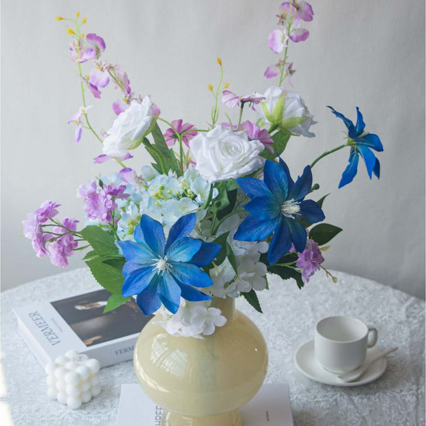 Handmade Clematis realistic artificial flower bouquet in a yellow vase with blue and pink flowers.