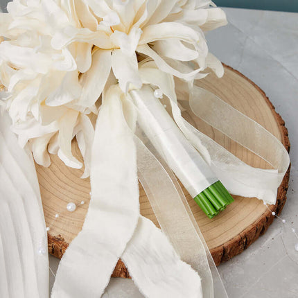 Artificial flower bouquet wedding accessory, highlighting a stylish cream white bouquet with a ribbon accent.