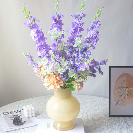 Handmade delphinium artificial flower arrangement in a vase for shop decor.