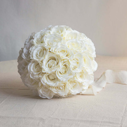 High-Quality artificial cream white silk rose bridal bouquet arrangement with ribbon on a soft background.