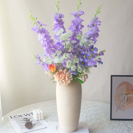 Handmade delphinium artificial flower arrangement in a vase for elegant shop decor.