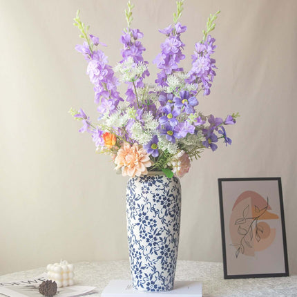 Handmade delphinium artificial flower arrangement in a decorative vase for shop decor.