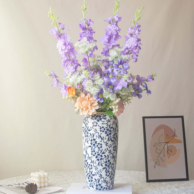 Handmade delphinium artificial flower arrangement in a decorative vase for shop decor.