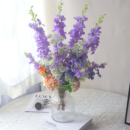 Handmade delphinium artificial flower arrangement in a glass vase for home decor.
