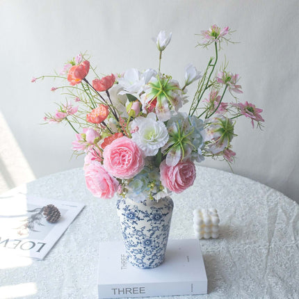 Handmade Pink-white Silk artificial flower arrangement in a decorative vase on a table.