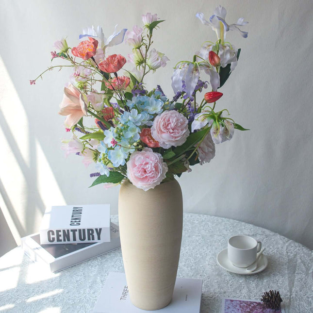 Realistic artificial Peony flower arrangement in vase, handmade table decor with various colorful flowers.