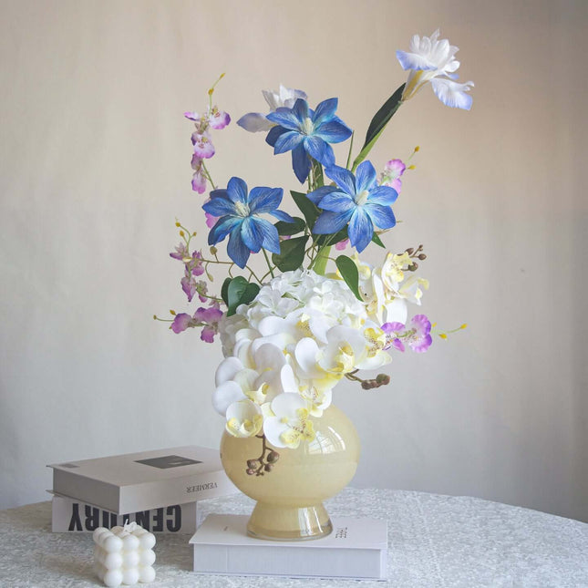 Handmade high-realism Orchid artificial flower bouquet in a yellow vase, shop decor with blue and white flowers.